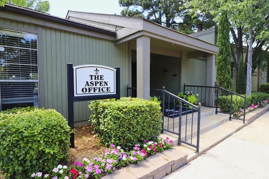 Aspen Apartments front side view of front office with sign in  Shreveport
